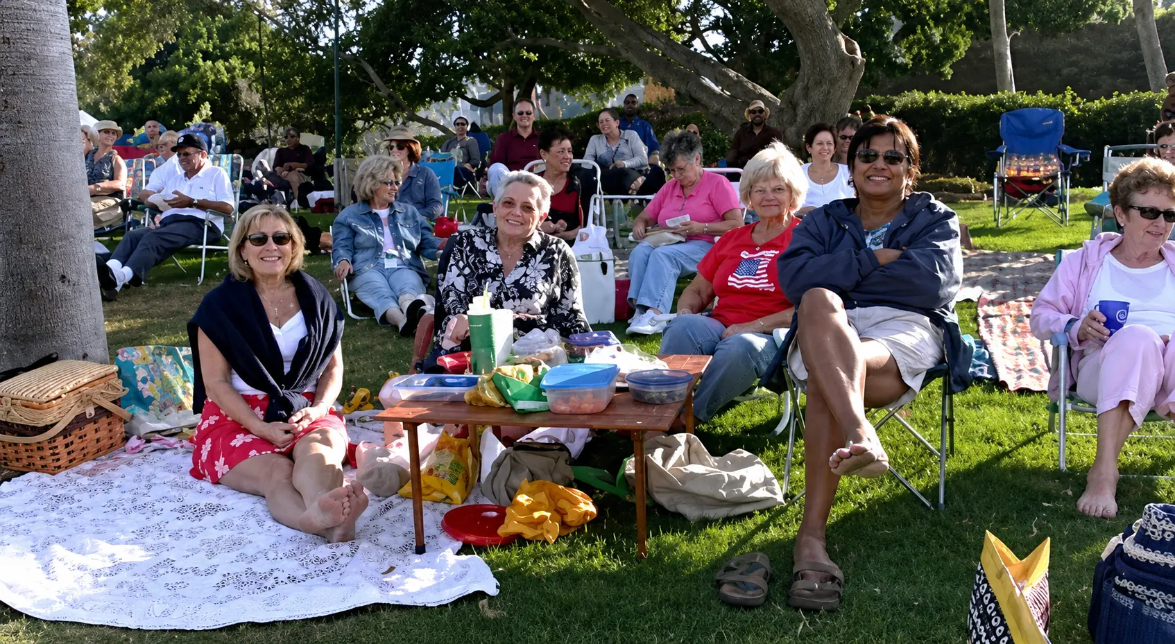 A relaxed crowd of music lovers enjoying a summer outdoor house concert