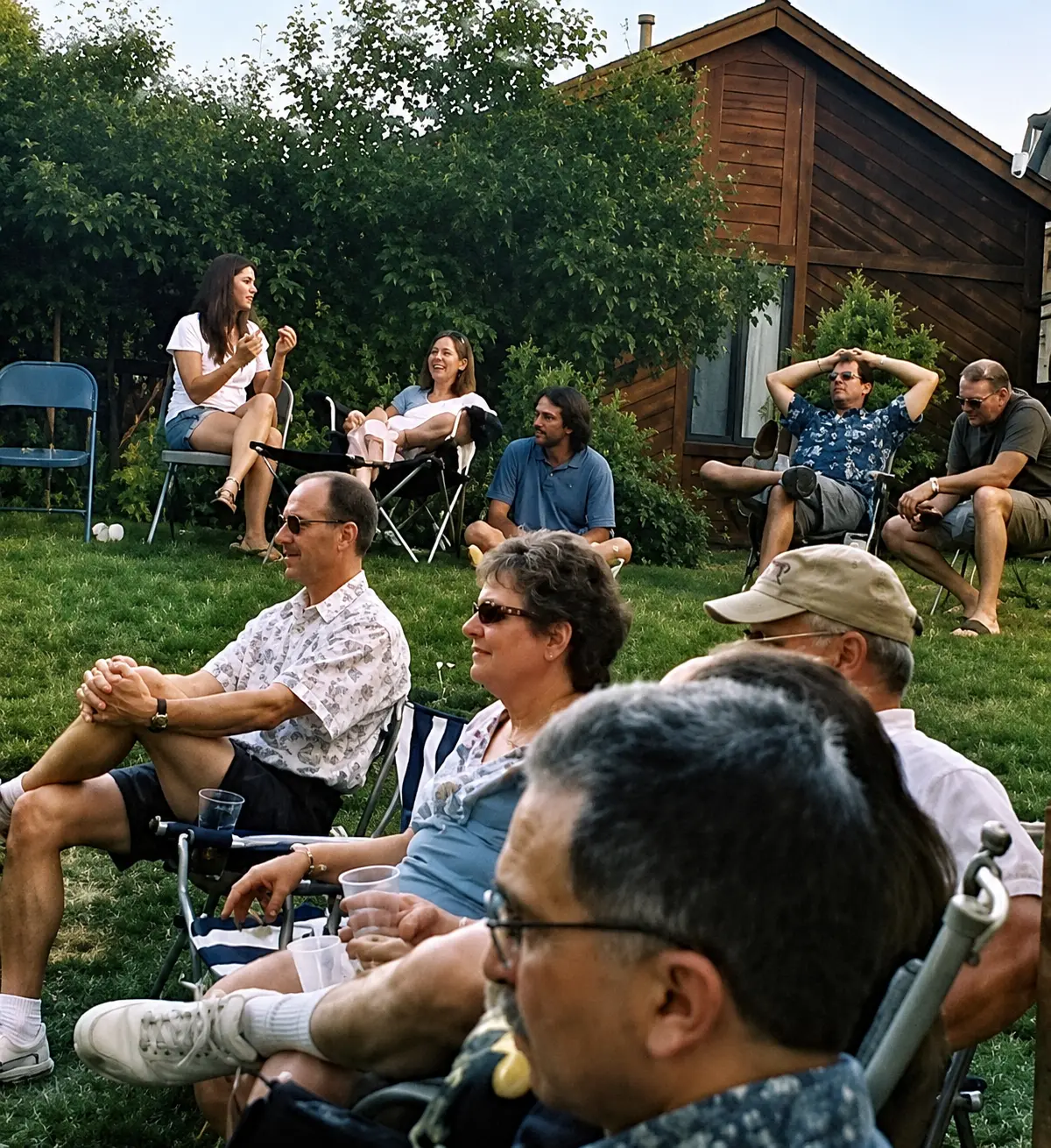 Guests relaxing in lawn chairs at an outdoor house concert